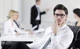 handsome young business man with colleagues in background